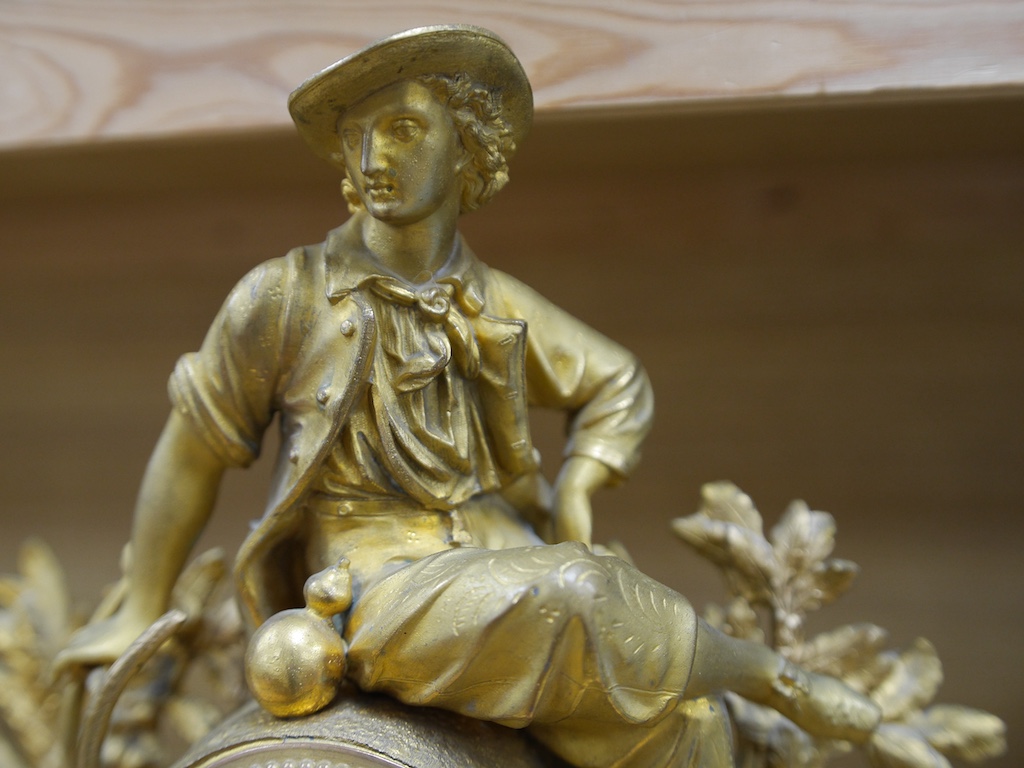 A 19th century French gilt spelter with seated youth mantel clock, with key and pendulum, 43cm. Condition - fair to good, not tested